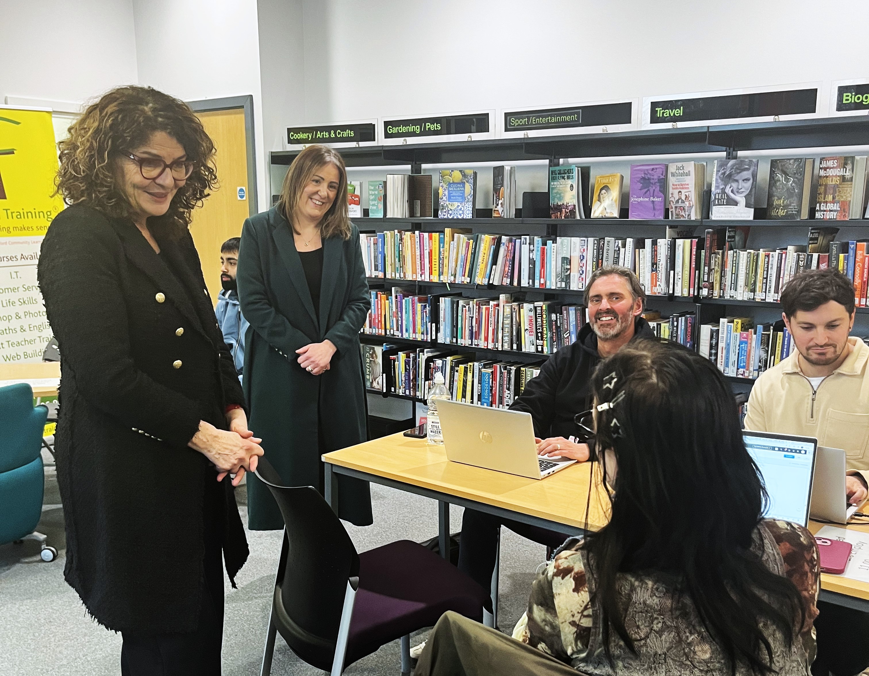 A group of people stood and sat chatting and smiling