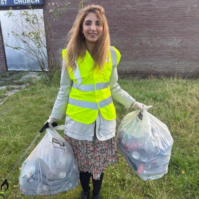 Councillor Mishal Saeed carrying two bags of collected litter