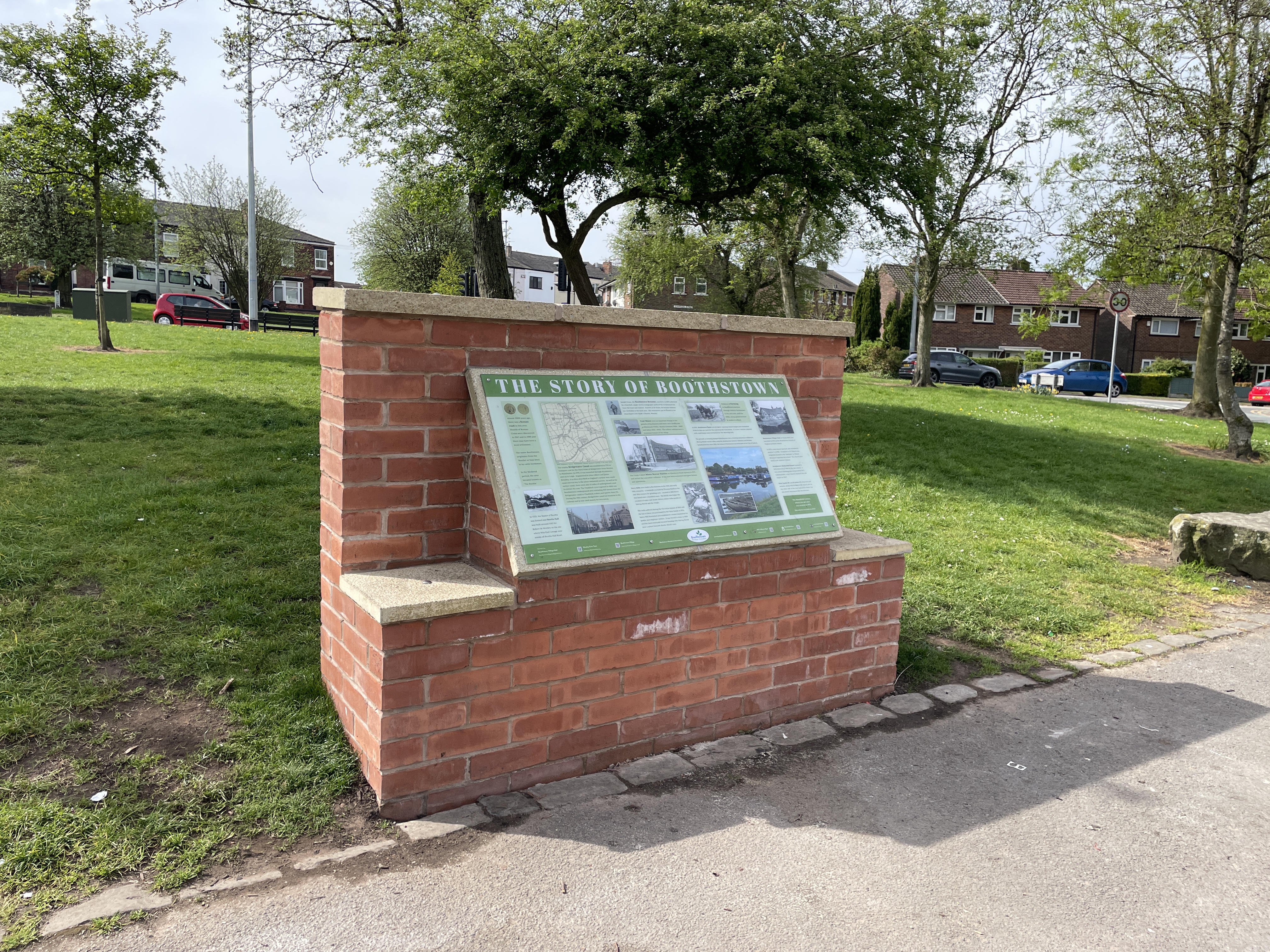 A plaque mounted to a wall which reads 'the story of Boothstown'