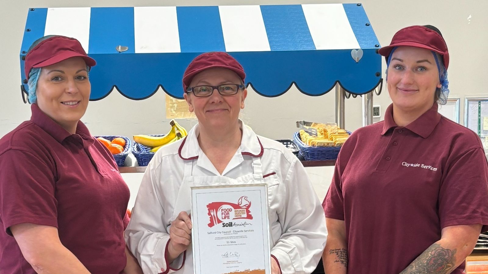 People holding award for the Bronze 'Food for Life' accreditation by the Soil Association