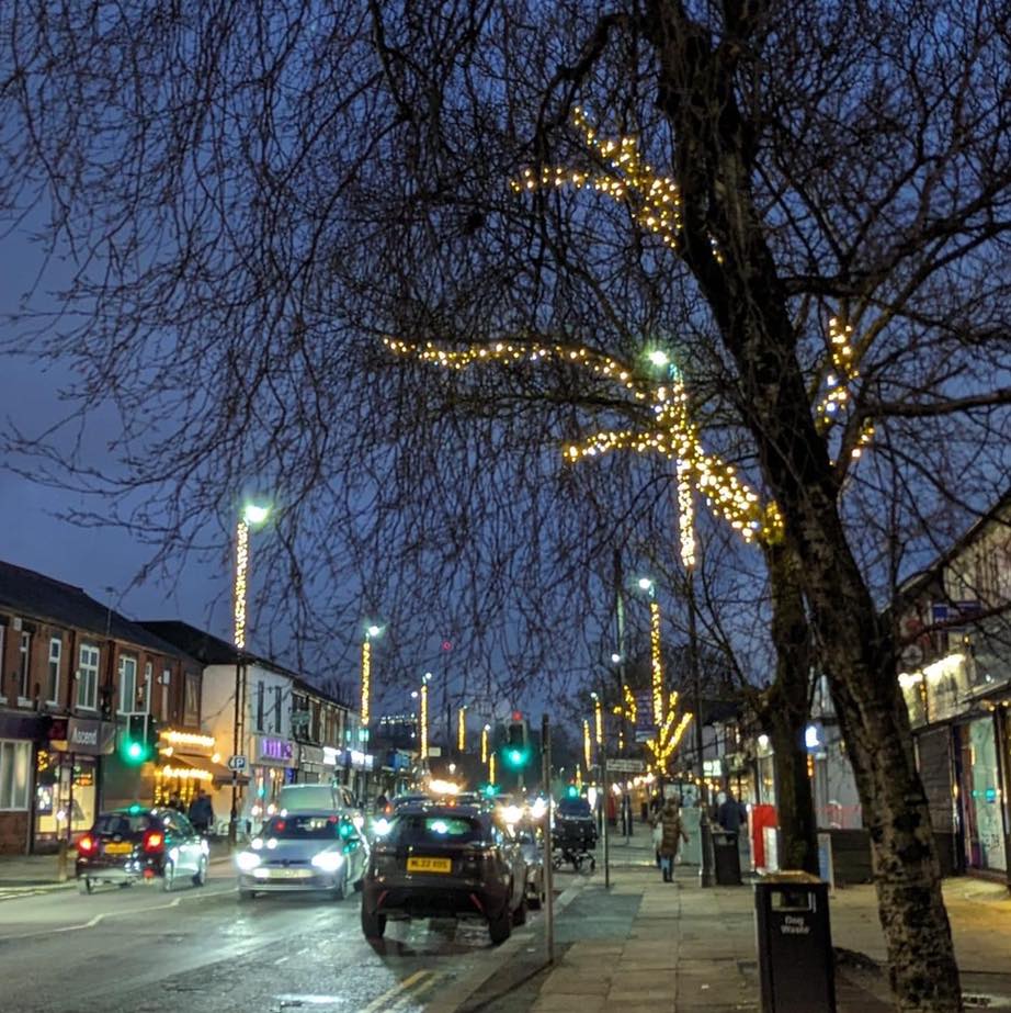 A street in Salford with Christmas lights on trees and lampposts