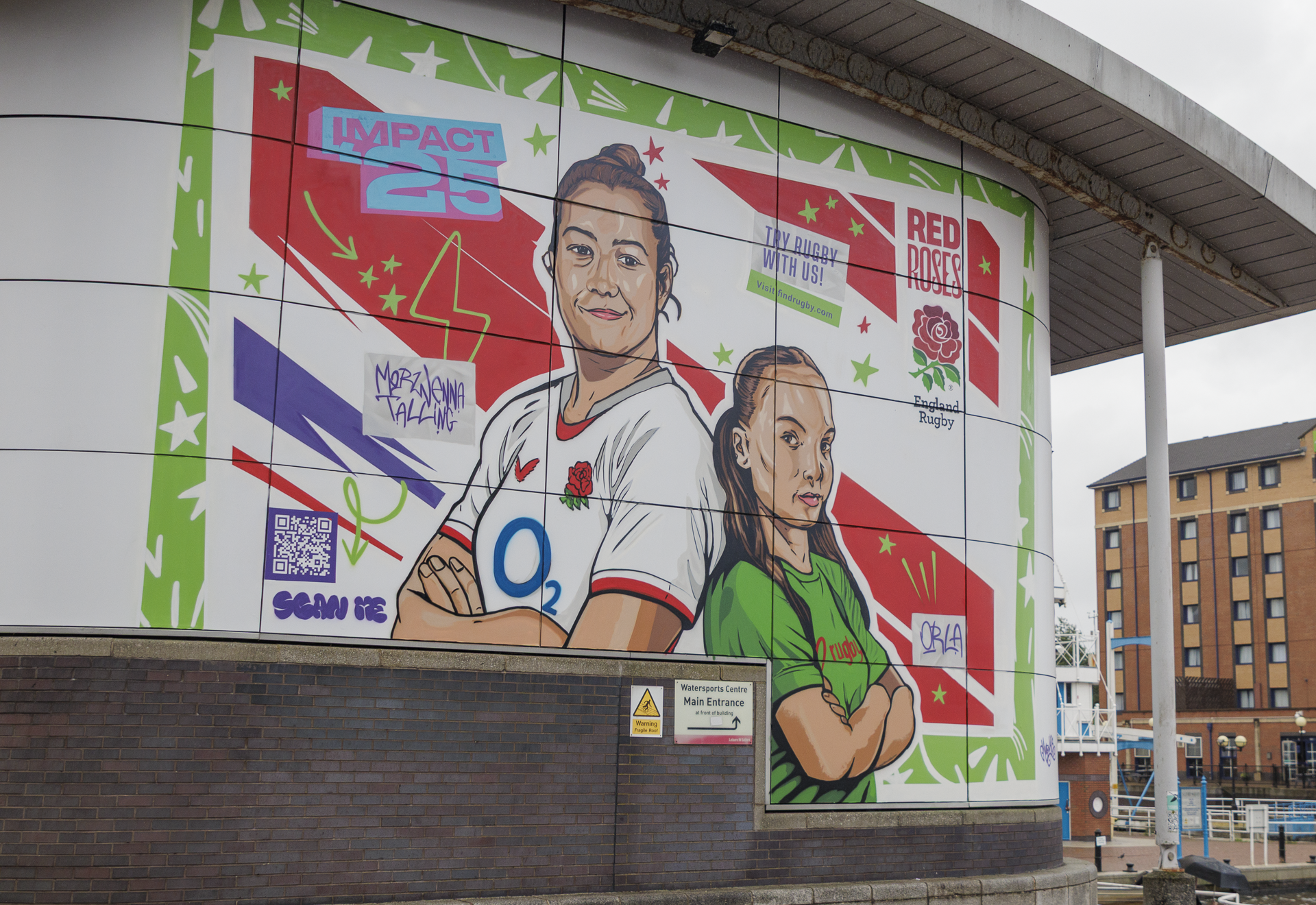 A mural featuring a Red Roses Player in their kit and local schoolgirl orla in a green top. The background is red, white and purple.