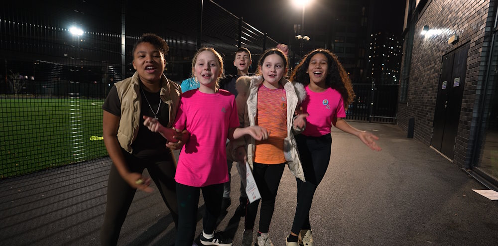 A group of children are smiling and cheering