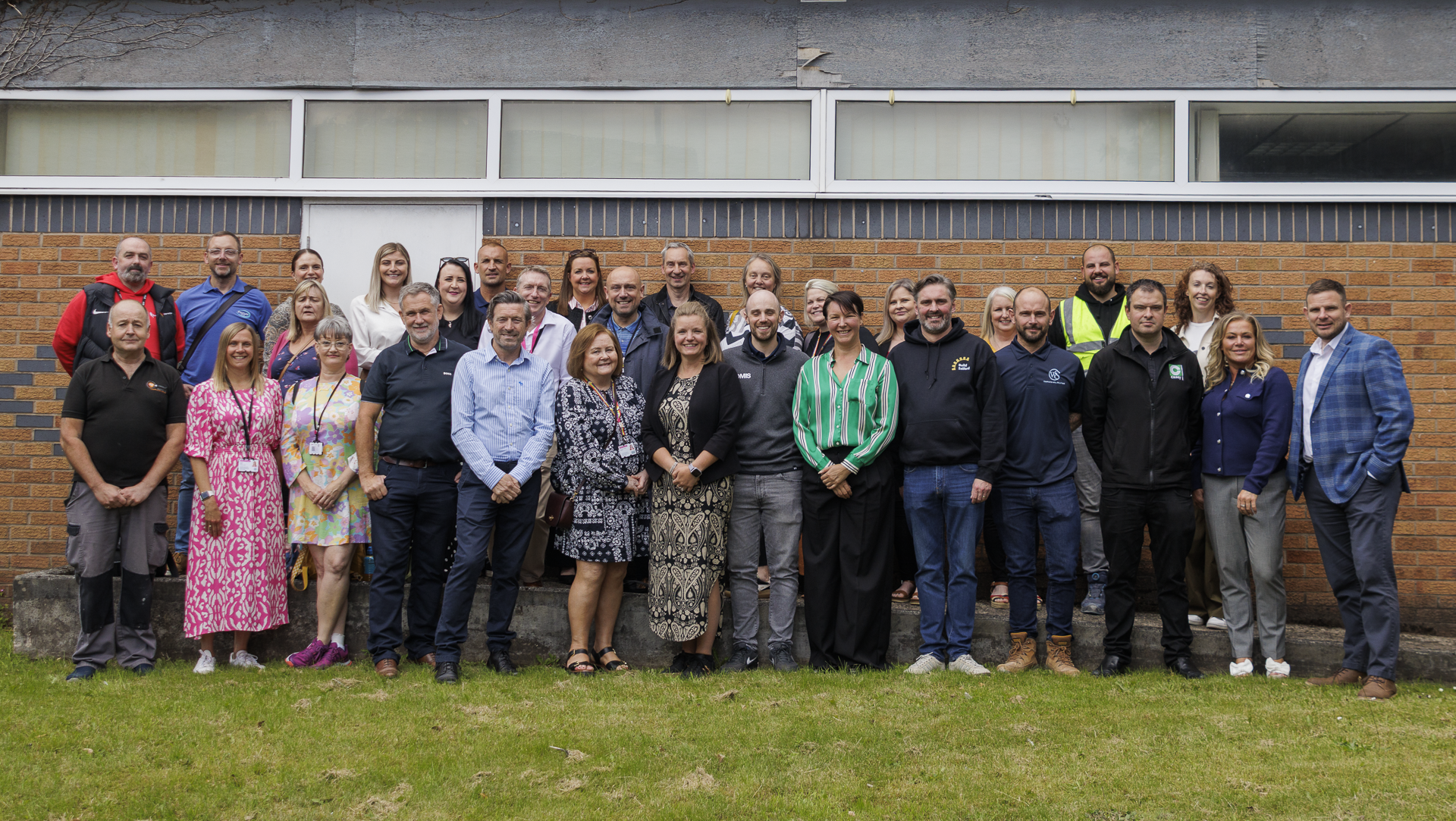 A group of people smiling and posing outside the new Construction Skills Centre