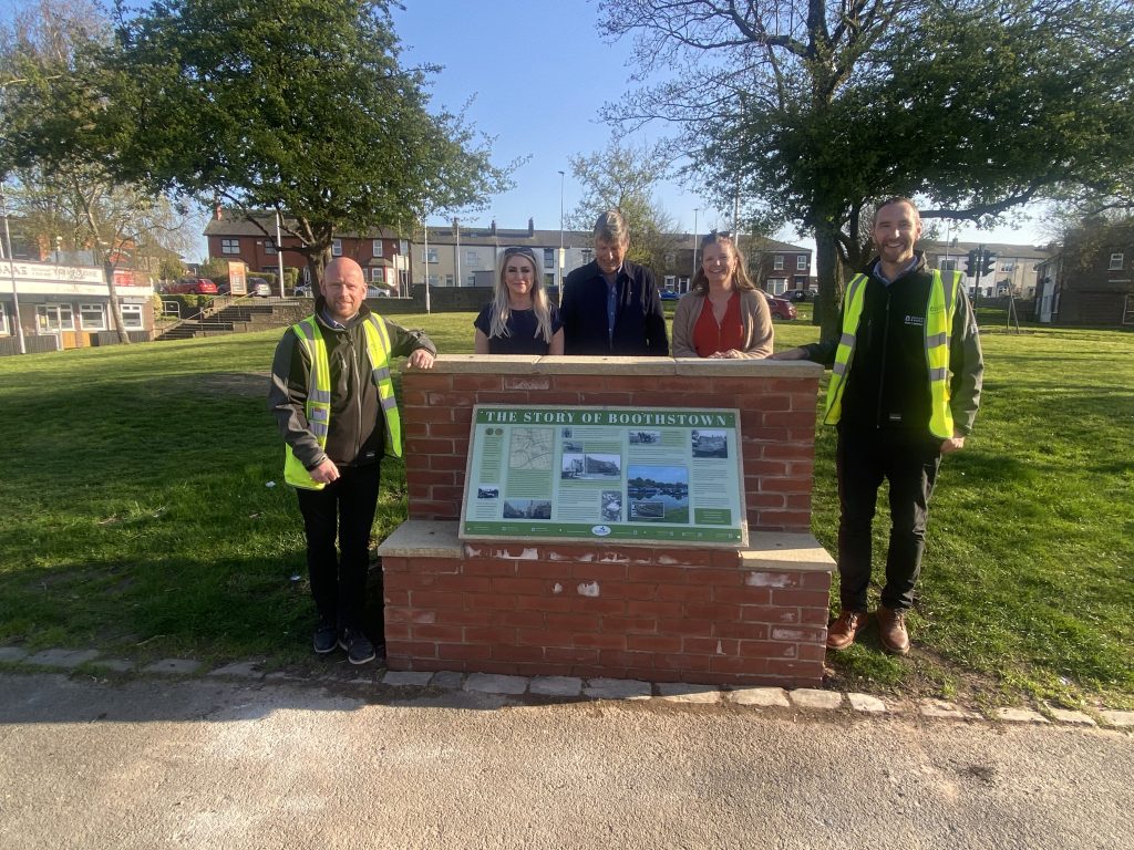 A group of people stood next to The Boothstown history plinth.