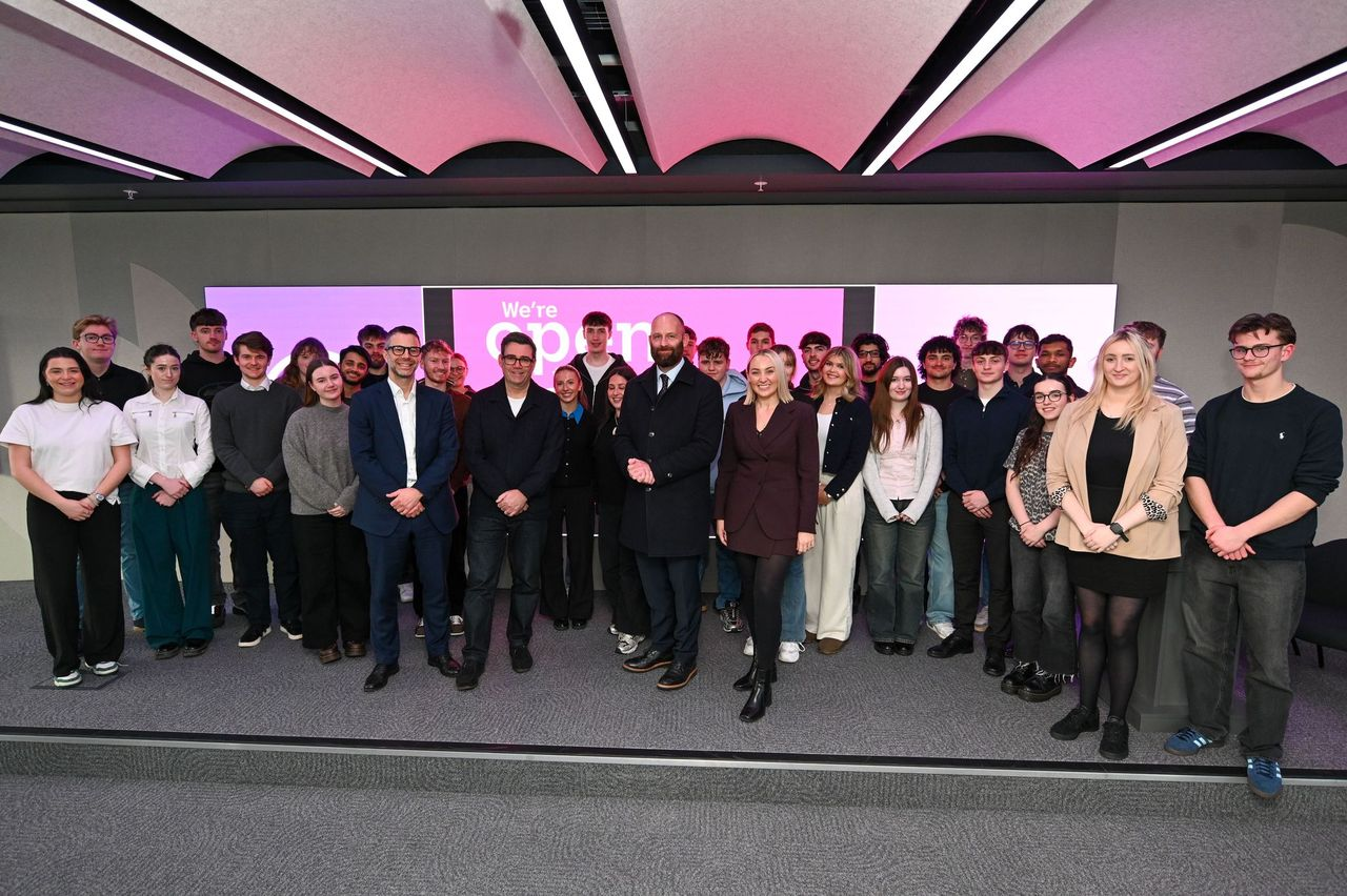 A group of peoole stood smiling