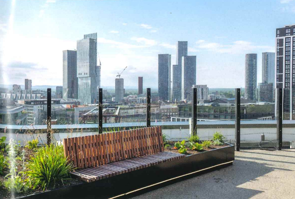 Rooftop garden with a wooden bench and planter box filled with various plants, set against a cityscape of tall skyscrapers and construction cranes under a partly cloudy sky.