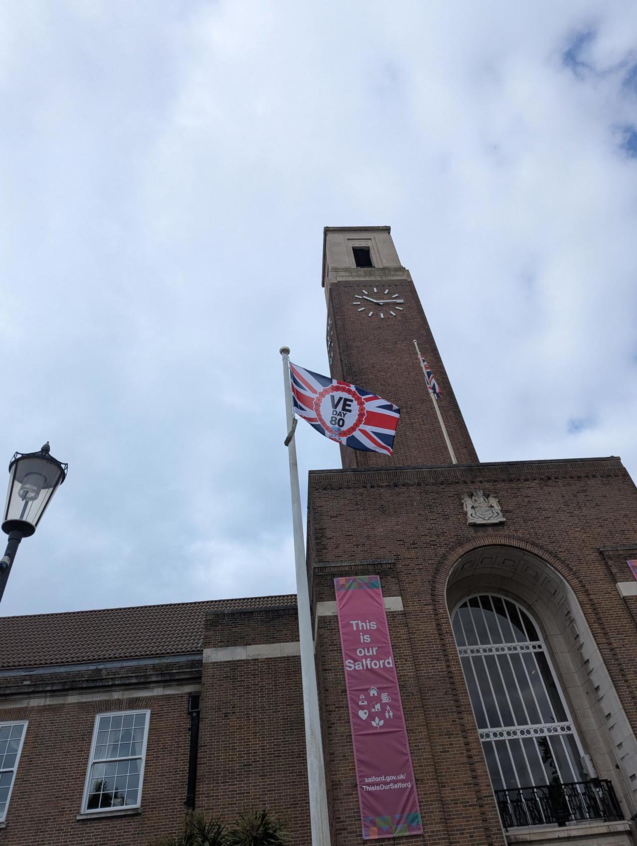 Image of VE Day 80 flag flying outside of Salford Civic Centre